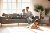 A photo of a father and daughter discussing her house sale on the family sofa